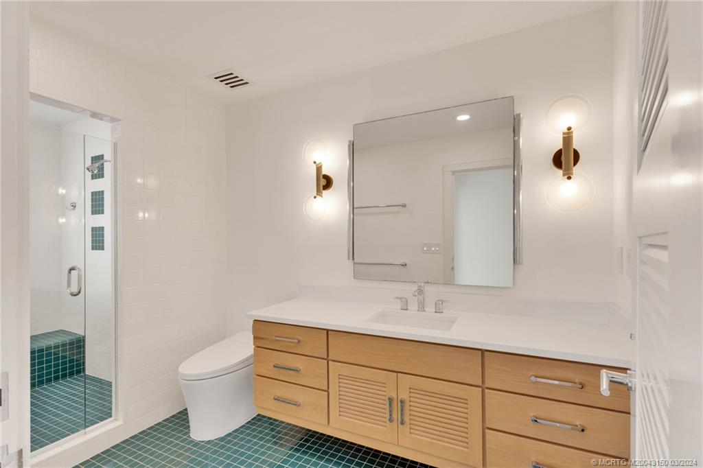 6996 Southeast Harbor Circle Stuart, FL 34996 - Photo 49 of 73 a bathroom with a toilet sink double vanity and mirror