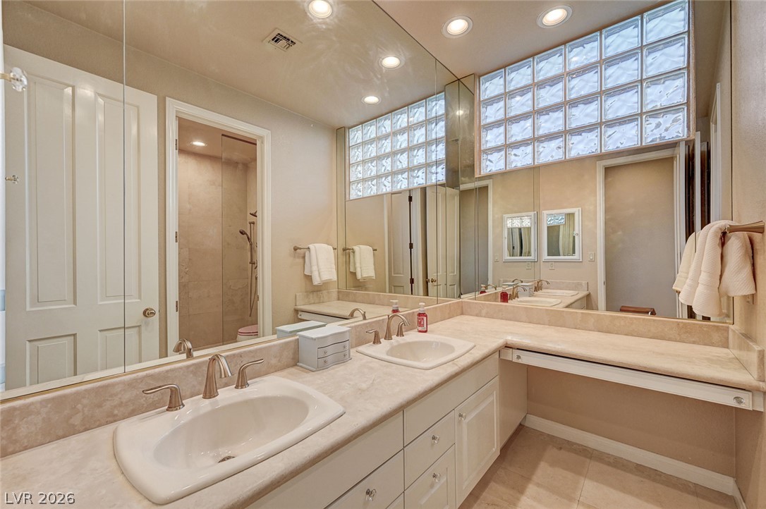 7995 Rio Rico Drive Las Vegas, NV 89113 - Photo 20 of 92 Dual vanities and a glass-enclosed shower create a refined bathing experience.