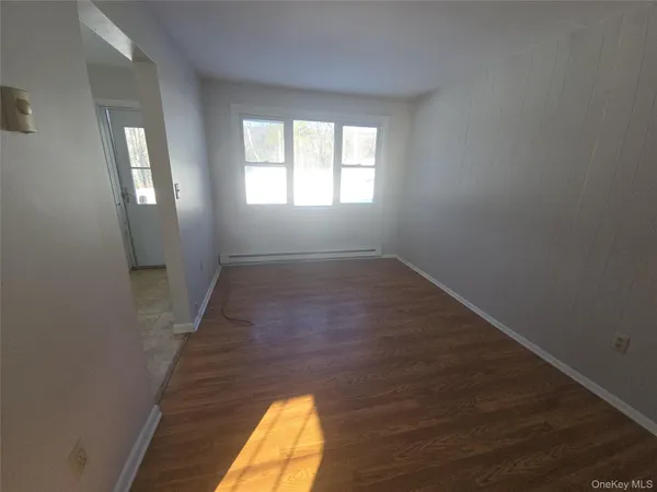 wooden floor in an empty room with a window