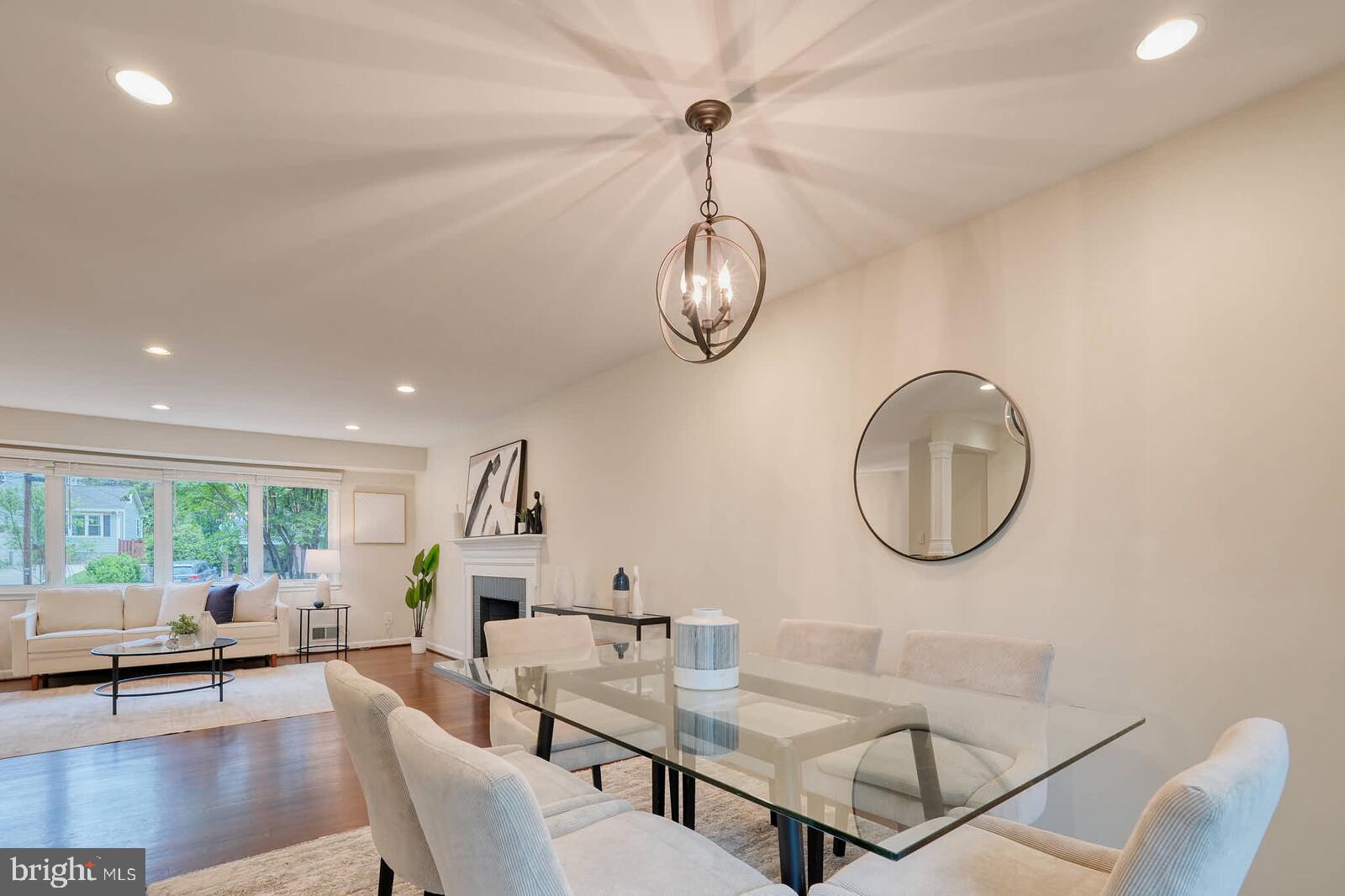6511 Engel Drive McLean, VA 22101 - Photo 12 of 56 a living room with couches a dining table and a chandelier