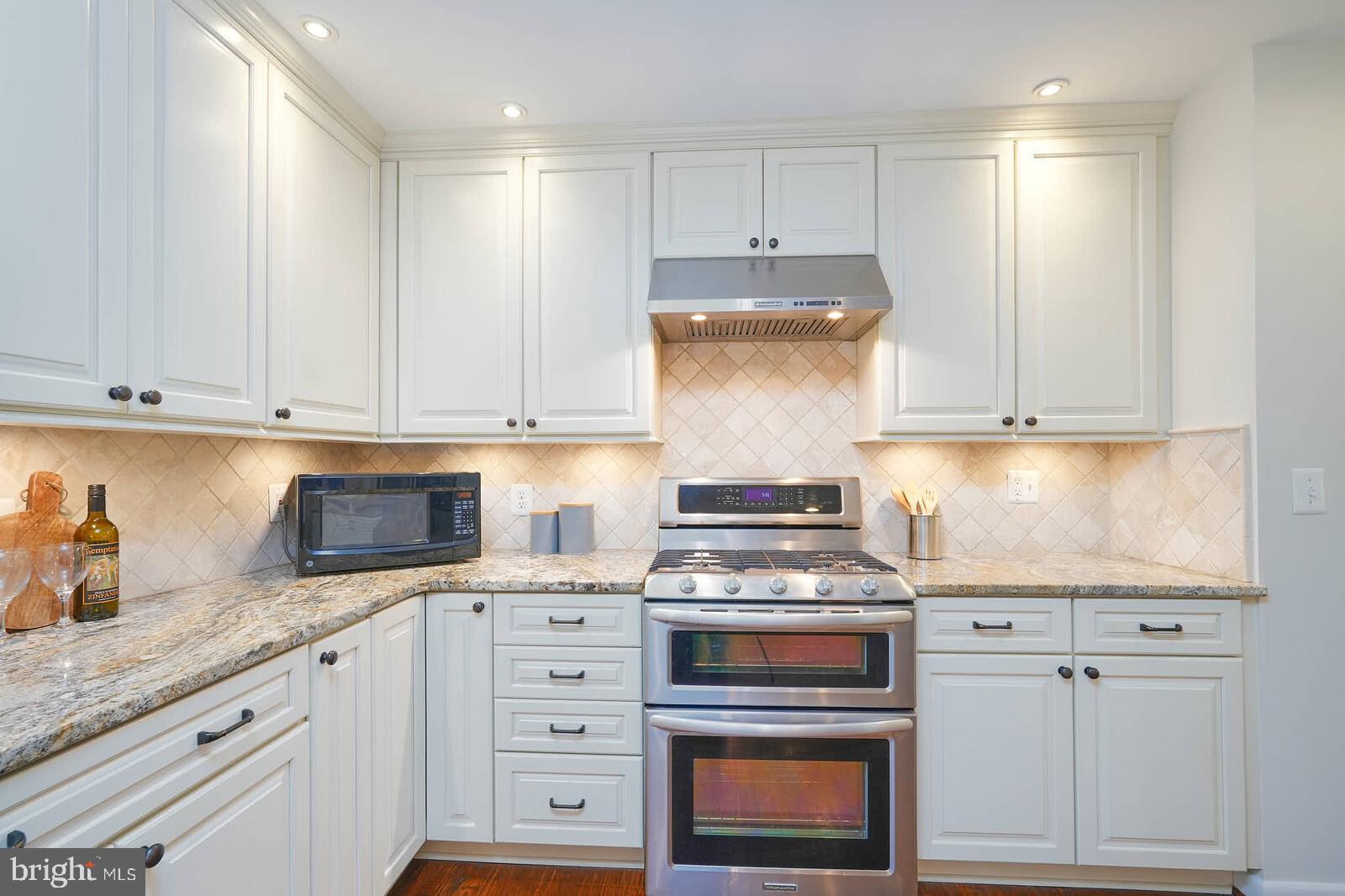 6511 Engel Drive McLean, VA 22101 - Photo 18 of 56 a kitchen with granite countertop white cabinets and white appliances