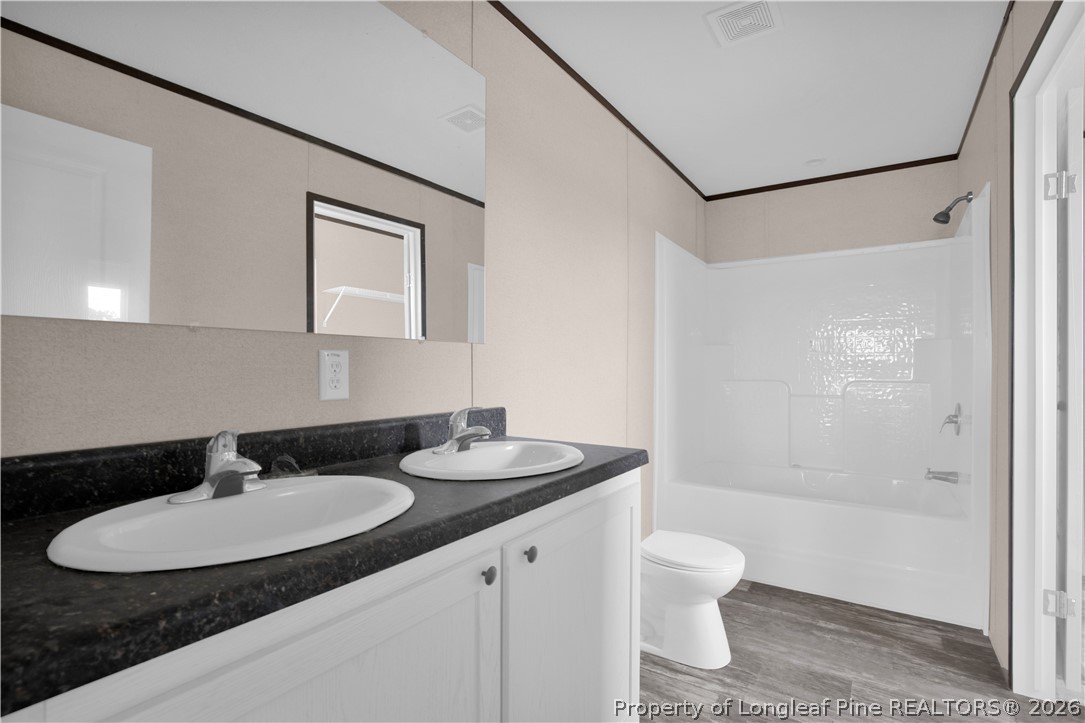 6309 Deep Branch Road Pembroke, NC 28372 - Photo 19 of 32 a bathroom with a granite countertop sink toilet a mirror and shower