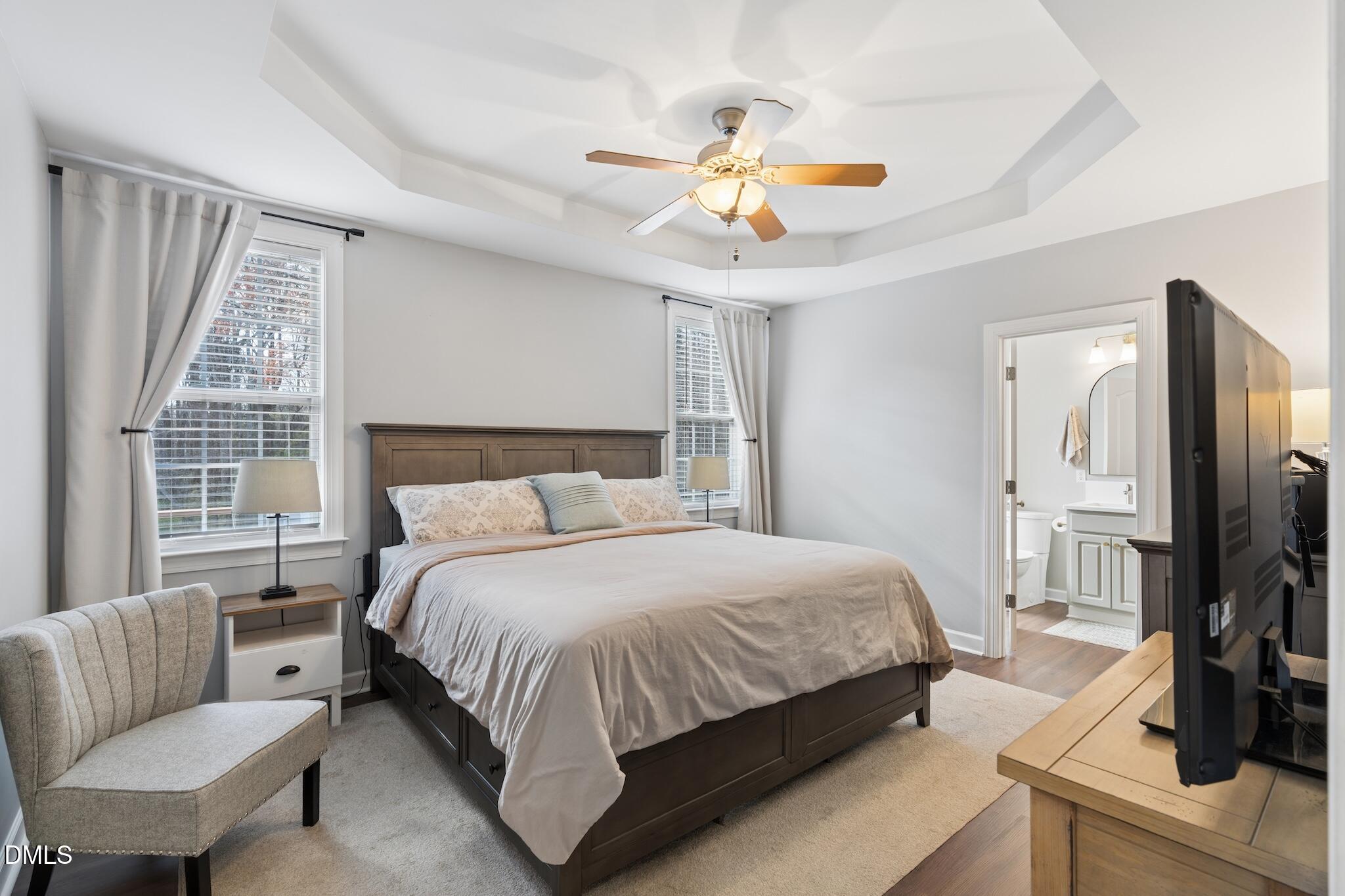 7340 Shady Stroll Lane Willow Spring, NC 27592 - Photo 26 of 67 a bedroom with a bed a chandelier and a flat screen television