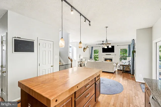 a view of kitchen island with stainless steel appliances refrigerator sink dining table and chairs