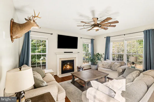 a living room with furniture a flat screen tv and a large window