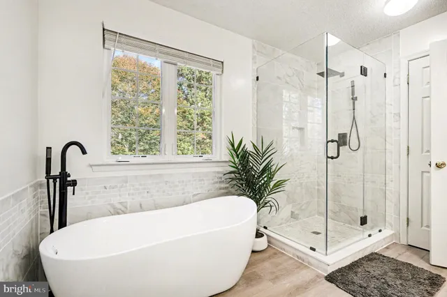 a white bath tub sitting next to a shower