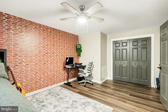 a view of a workspace with furniture and a ceiling fan