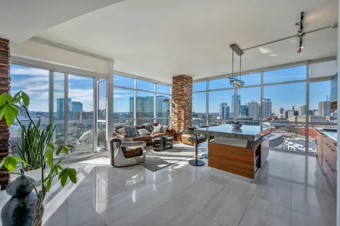 a living room with patio furniture and a floor to ceiling window