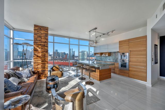 a living room with lots of furniture and kitchen view