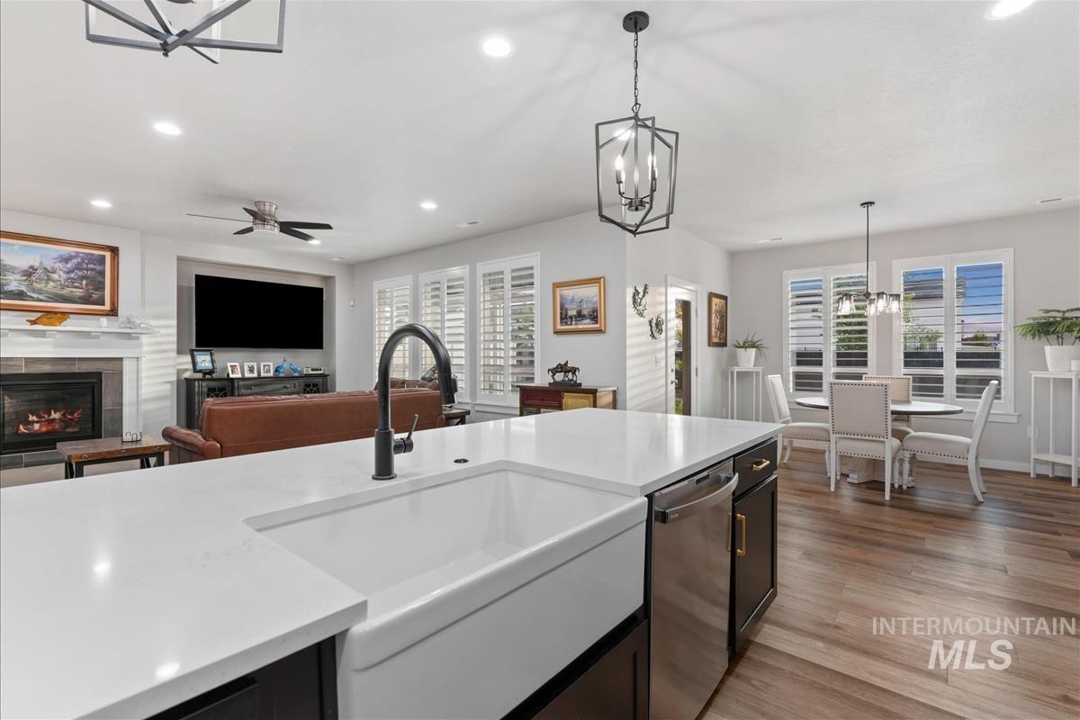 15451 Lutsen Avenue Caldwell, ID 83607 - Photo 15 of 39 Kitchen island featuring a white apron front sink, black faucet, and stainless steel dishwasher