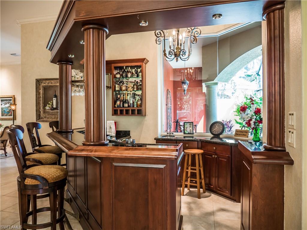 136 Hickory Road Naples, FL 34108 - Photo 16 of 34 Interior bar next to the kitchen, family room, living room an d extends outside into the central lanai perfect for entertaining and get togethers.