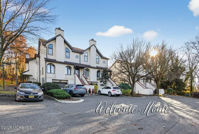 a front view of a house with a yard and car parked