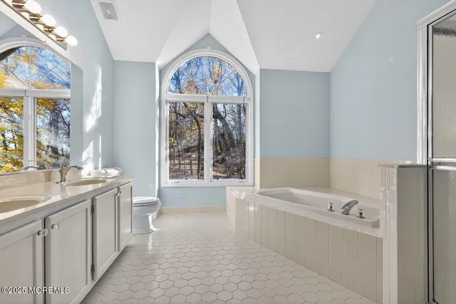 a bathroom with a tub sink and mirror
