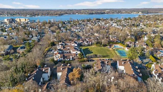an aerial view of a residential houses with outdoor space and trees
