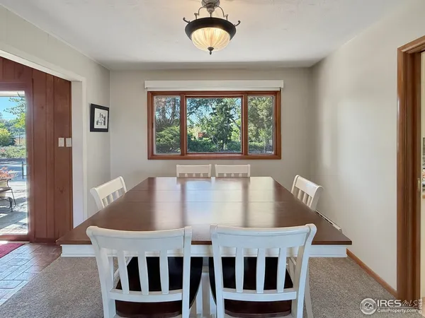 a kitchen with stainless steel appliances granite countertop a stove top oven a sink dishwasher a dining table and chairs with wooden floor