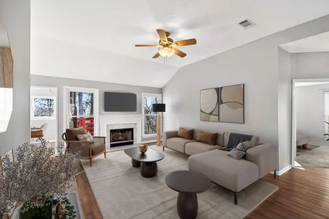 a living room with furniture a fireplace and a flat screen tv