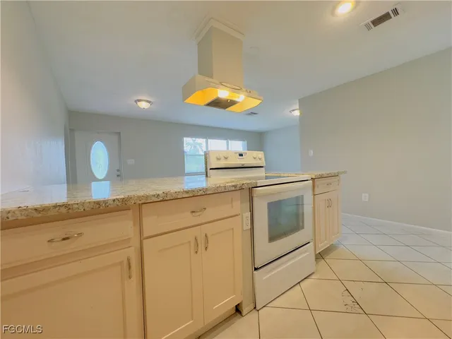 a kitchen with stainless steel appliances granite countertop a stove a sink and a microwave