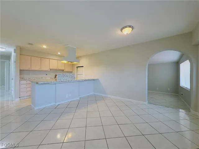a open kitchen with kitchen island granite countertop a sink and a stove top oven