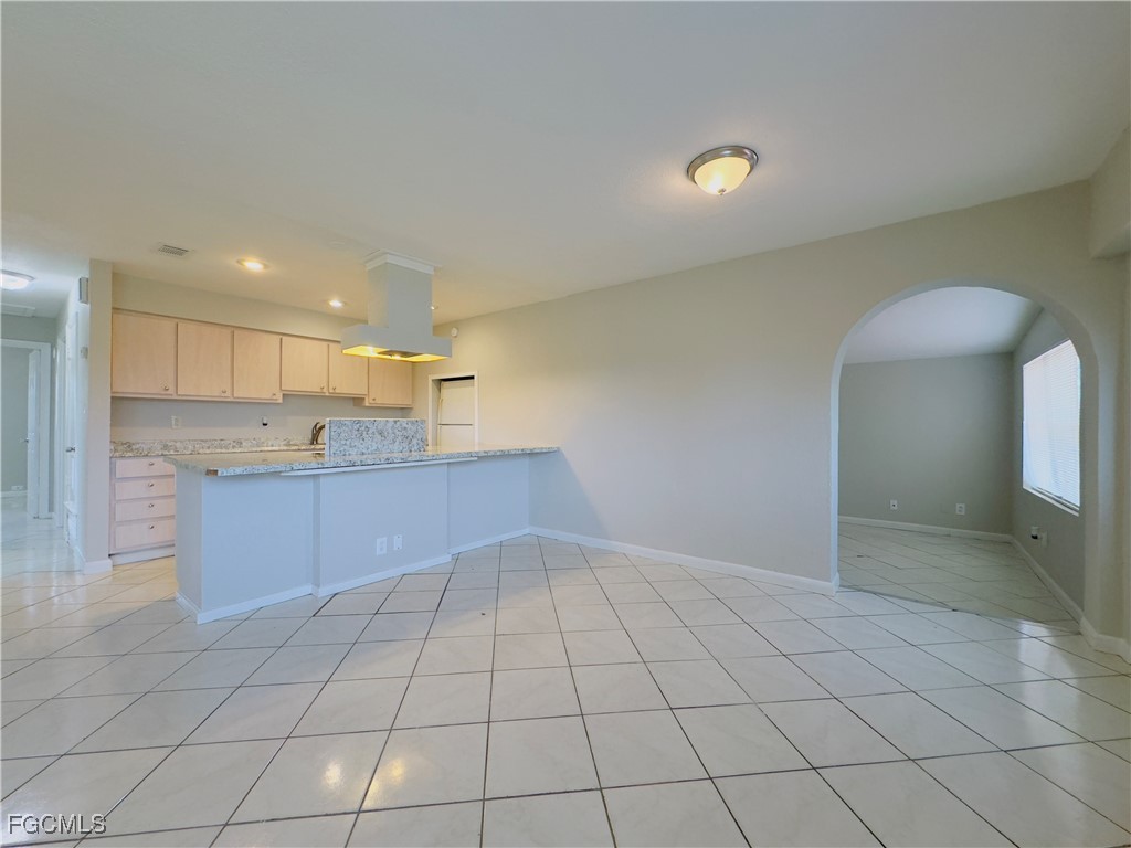 913 Hudson Avenue Lehigh Acres, FL 33936 - Photo 15 of 36 a open kitchen with kitchen island granite countertop a sink and a stove top oven