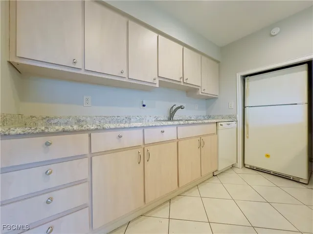 a kitchen with granite countertop white cabinets and a sink