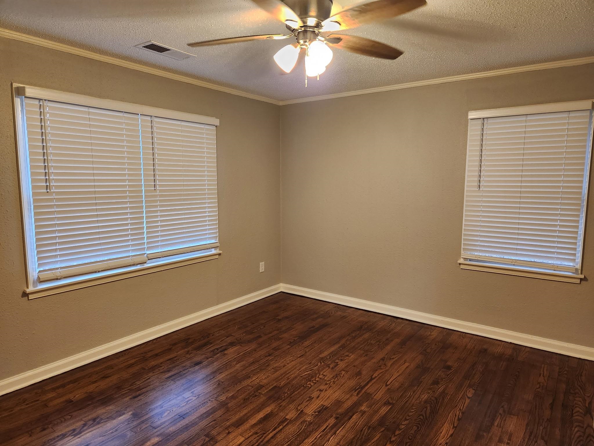 866 Colonial Road Memphis, TN 38117 - Photo 10 of 15 Spare room with crown molding, a textured ceiling, dark wood finished floors, and ceiling fan