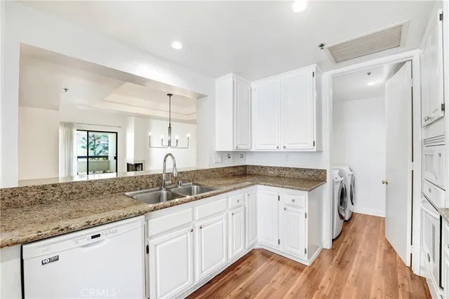 a view of a sink and dishwasher with wooden floor