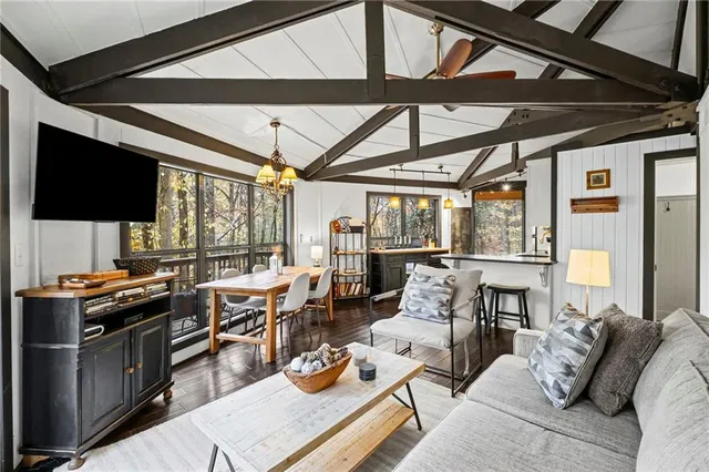 a living room with furniture a flat screen tv and a floor to ceiling window