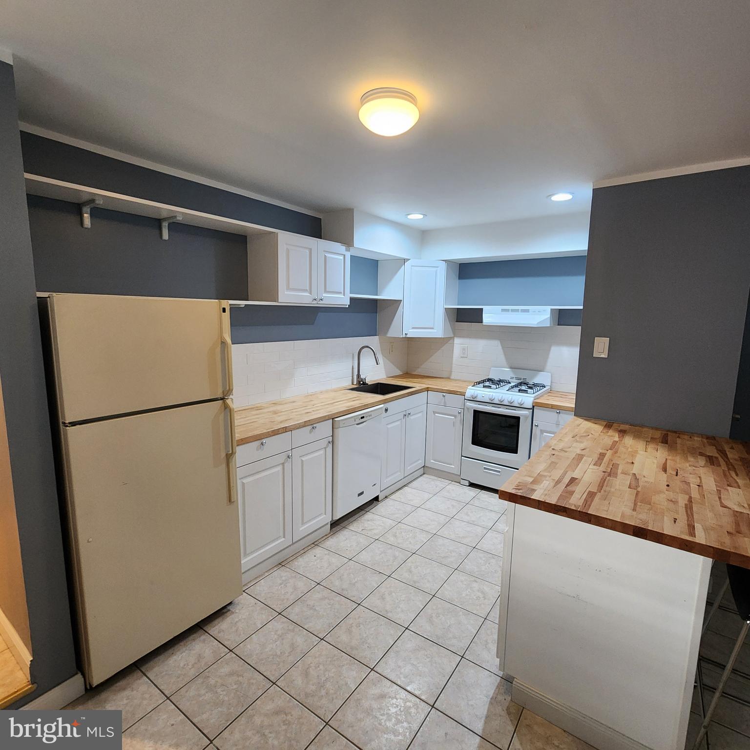1539 East Moyamensing Avenue, Unit 1R Philadelphia, PA 19147 - Photo 3 of 7 a kitchen with a refrigerator sink and cabinets