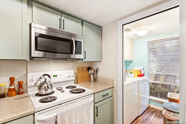 a kitchen with a microwave a stove and cabinets