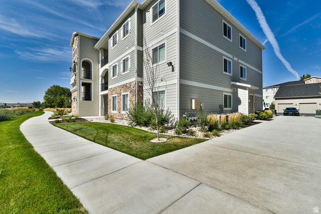 Multi-story building featuring a stucco and stone facade with gray siding