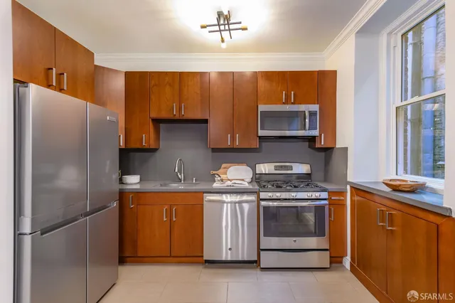 a kitchen with stainless steel appliances granite countertop a stove a refrigerator and a sink