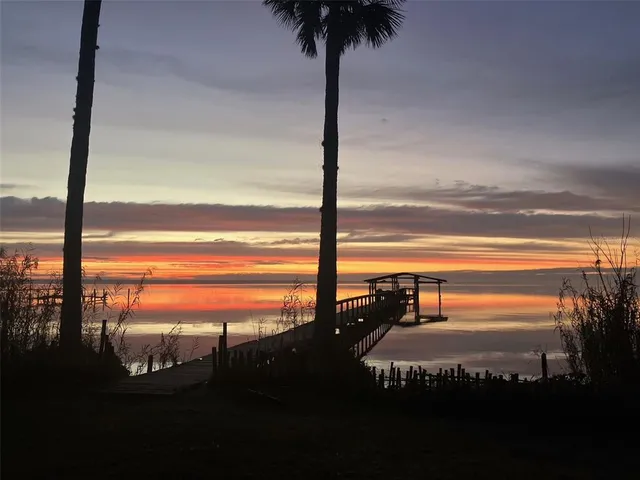 a view of a dining room with furniture large windows and wooden floor