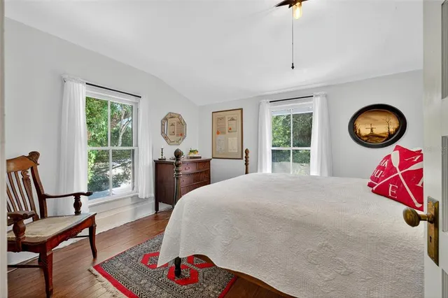 a living room with stainless steel appliances kitchen island a table chairs in it and wooden floors