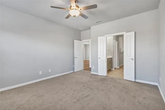 a view of an empty room and a ceiling fan