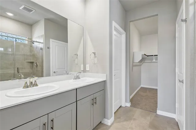 a bathroom with a double vanity sink and mirror
