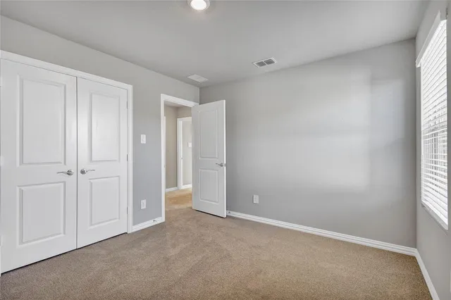 an empty room with windows and closet