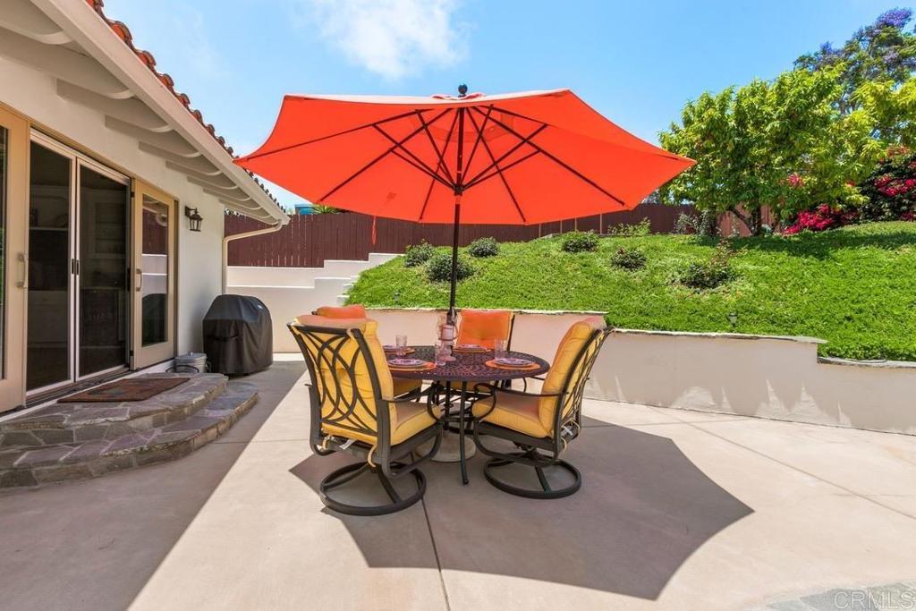 234 Winterhawk Lane Encinitas, CA 92024 - Photo 16 of 20 a patio with a table and chairs under an umbrella
