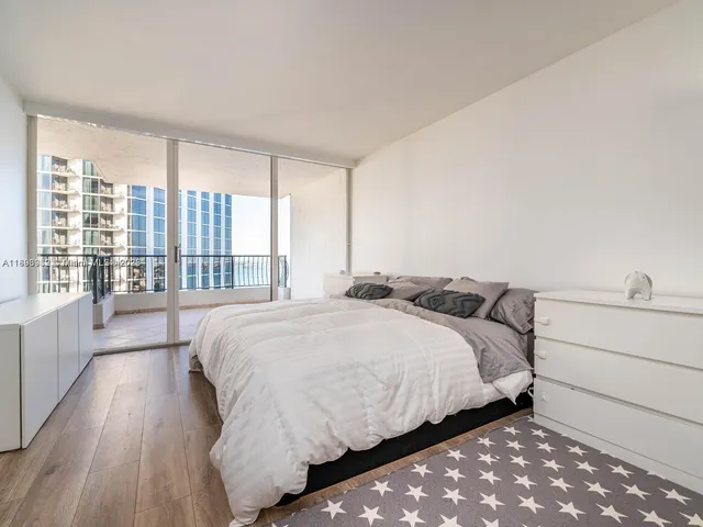 a bedroom with a bed and a large window