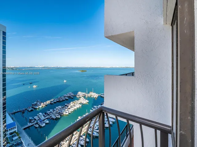 a view of an ocean with boats and trees in the background