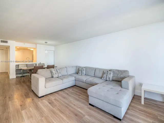 a living room with couches and a coffee table with wooden floor