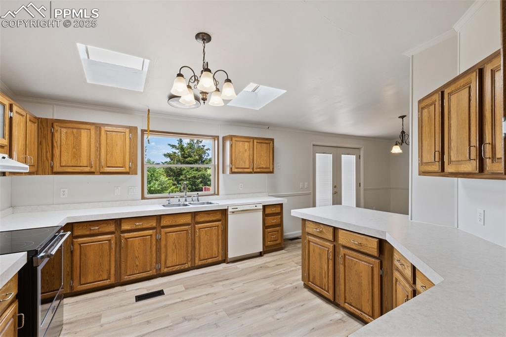 16175 Cathys Loop Peyton, CO 80831 - Photo 15 of 35 a large kitchen with stainless steel appliances wooden floor and large window