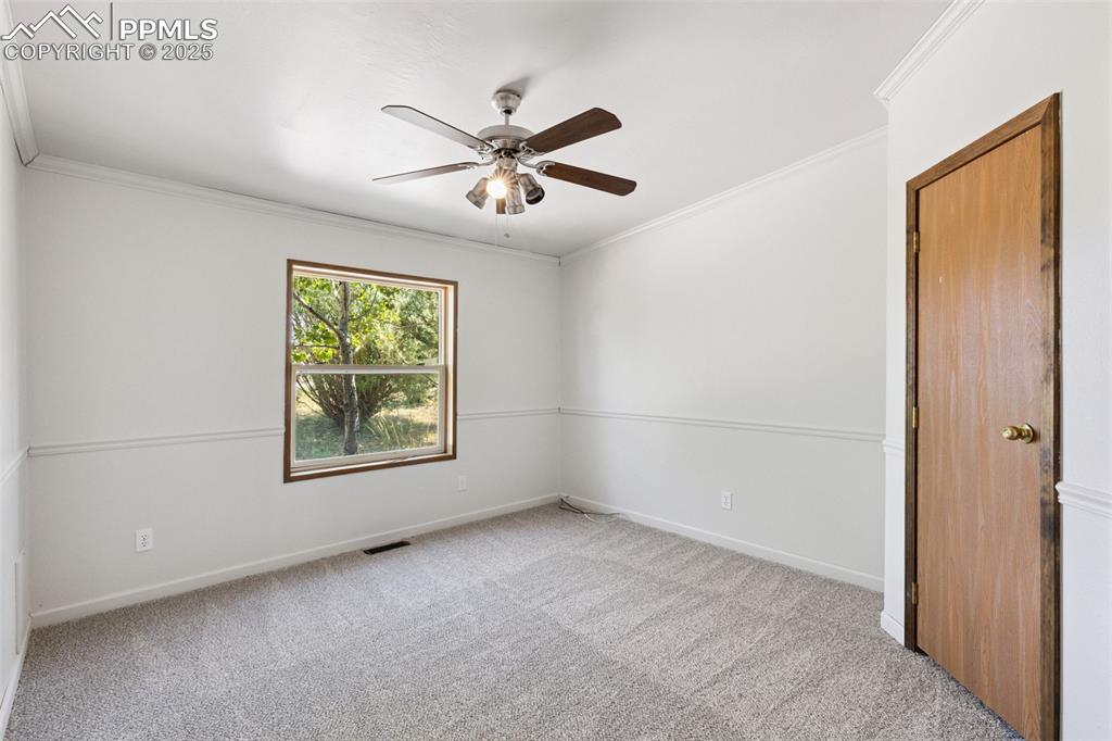 16175 Cathys Loop Peyton, CO 80831 - Photo 19 of 35 an empty room with windows and fan