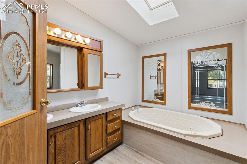 16175 Cathys Loop Peyton, CO 80831 - Photo 22 of 35 a bathroom with a granite countertop tub sink and mirror