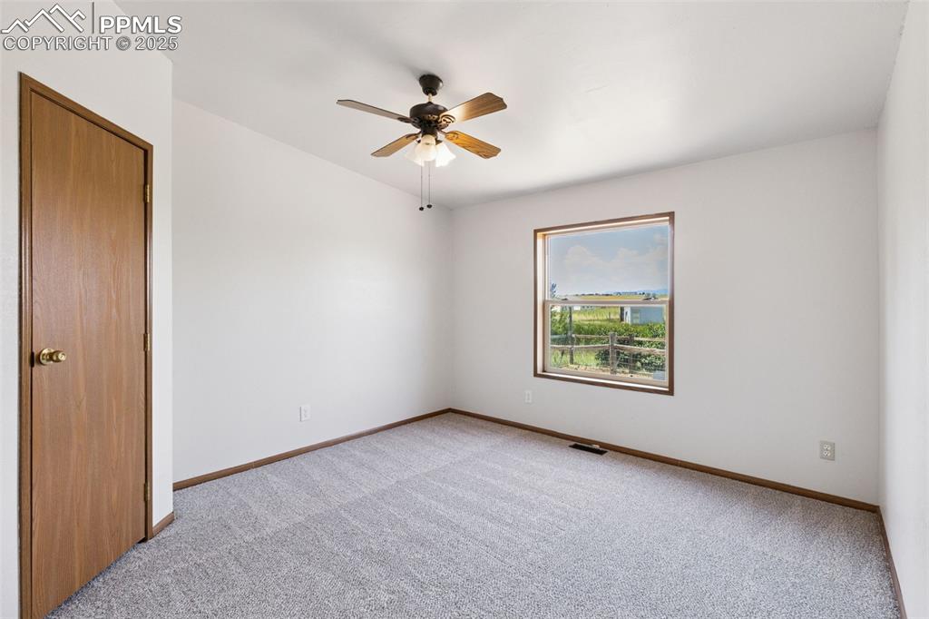 16175 Cathys Loop Peyton, CO 80831 - Photo 28 of 35 an empty room with windows and fan
