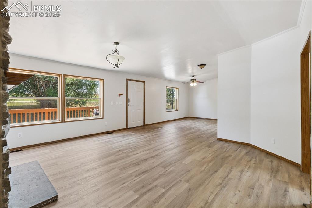 16175 Cathys Loop Peyton, CO 80831 - Photo 7 of 35 a view of an empty room with wooden floor and windows