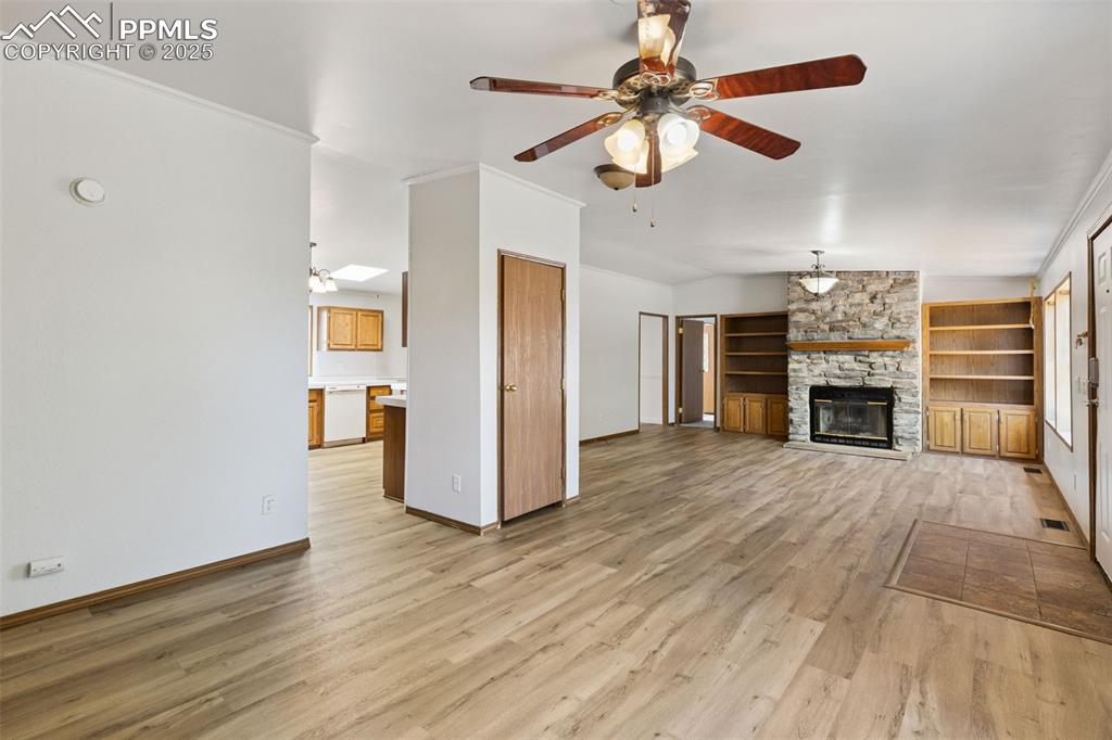 16175 Cathys Loop Peyton, CO 80831 - Photo 8 of 35 a view of a livingroom with a fireplace a ceiling fan and wooden floor