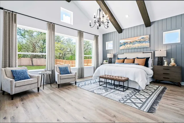 a bedroom with a bed a couch and large window