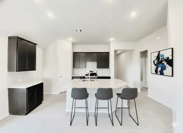 a kitchen with a sink and a stove top oven with wooden floor