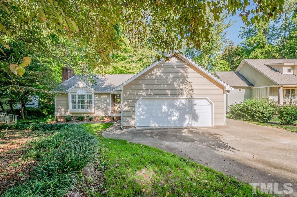 215 Lawrence Road Cary, NC 27511 - Photo 1 of 28 a front view of a house with a garden and trees
