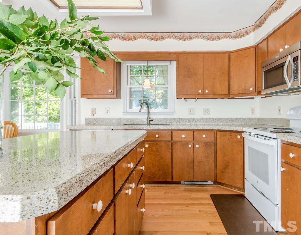 215 Lawrence Road Cary, NC 27511 - Photo 12 of 28 a kitchen with stainless steel appliances granite countertop a sink a stove and a microwave